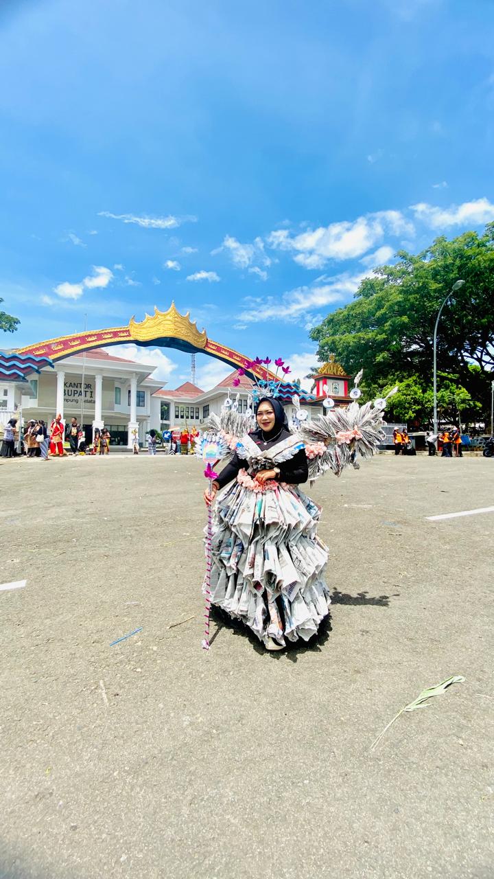 Sosok Guru Berkreasi, Deliana Sulap Koran Bekas Jadi Gaun Memukau di Pawai Budaya Lamsel Fest 2025